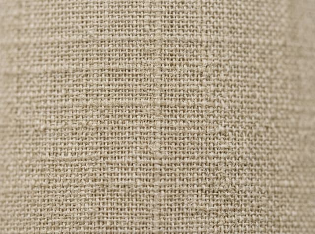 Close-up of loom-state greige cloth: natural fiber color and visible interlacing before bleach or dye.