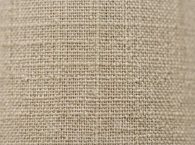 Close-up of loom-state greige cloth: natural fiber color and visible interlacing before bleach or dye.